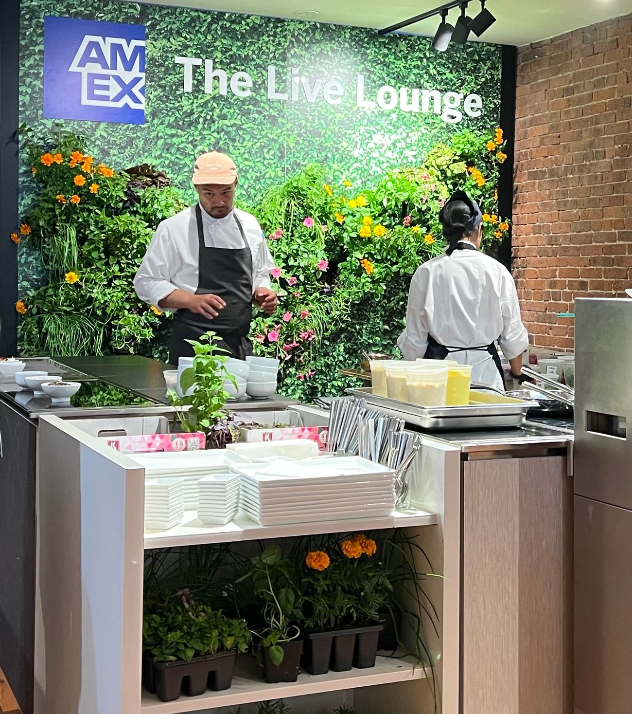 Chef cooking in front of the living wall Longo Advertising designed for the AMEX Live Lounge with Sodexo